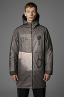 Person wearing a gray jacket with 'TELL' branding on a gray background